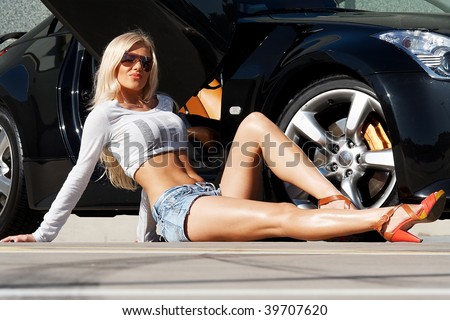 Sexy babe sitting in front of tuned supercar