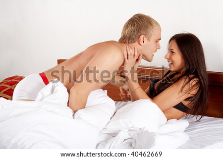 Young couple having fun and laughing in bed