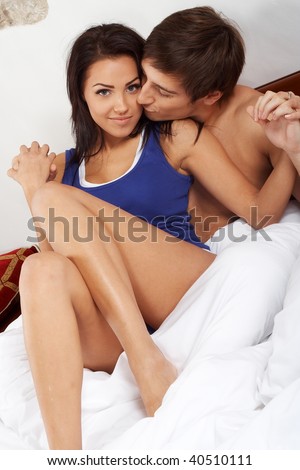 stock photo Young happy couple kissing in a bed