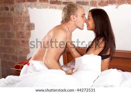 Young couple having fun and laughing in bed