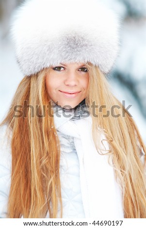Young woman in fur-cap in a winter park