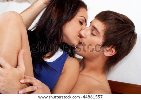 stock photo Young couple kissing in a bed