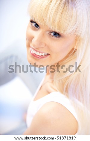 Closeup portrait of beautiful female model with blue eyes in blue jeans on white background