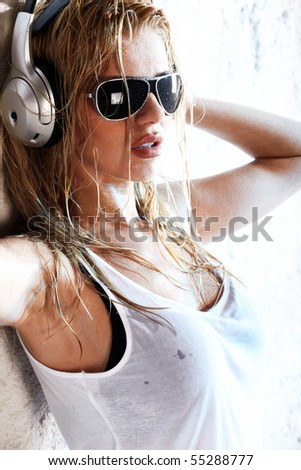 stock photo Wet woman in white shirt and sunglasses listening for the 