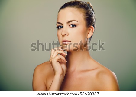Portrait of beautiful female model on grey background with cross processing toning