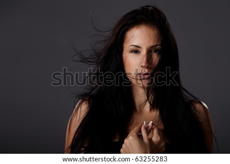 stock photo Natural brunette woman portrait with flying hair on grey 