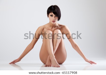 stock photo Young beautiful naked woman sitting on a floor