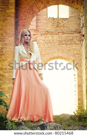 Beautiful young lady in long dress at old manor