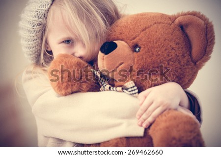 Portrait of an adorable preschool age girl playing with a teddy bear