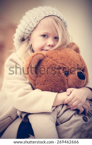 Portrait of an adorable preschool age girl playing with a teddy bear