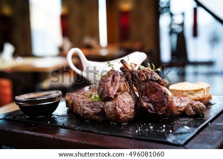 Mixed grilled meat platter. Assorted delicious grilled steaks served with goat cheese on warm dish.