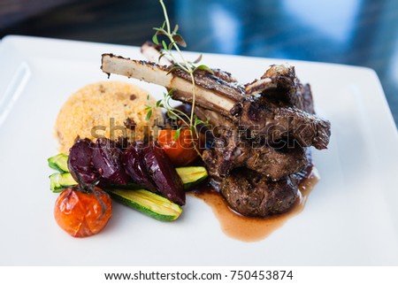 Grilled lamb carre with warm couscous salad, roasted vegetables, Dijon mustard and red wine sauce