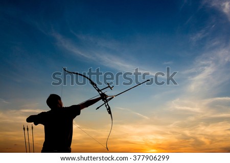 A silhouette of an archer drawing his bow and aiming upwards with colorful and dramatic sky as background