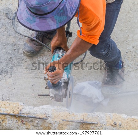 Man worker cutting concrete with Circular saw.
