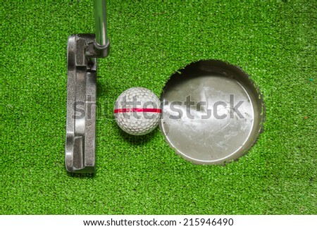 Close up, Old golf balls and putter on artificial grass for practice putting to hole.