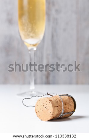 Champagne glass and cork on table