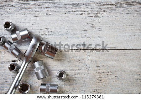Socket wrench on painted wood background