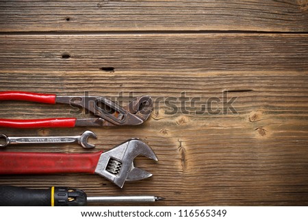 Tools for repairs on the old wooden background