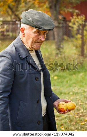 Old man walking at outdoor, apple in hand