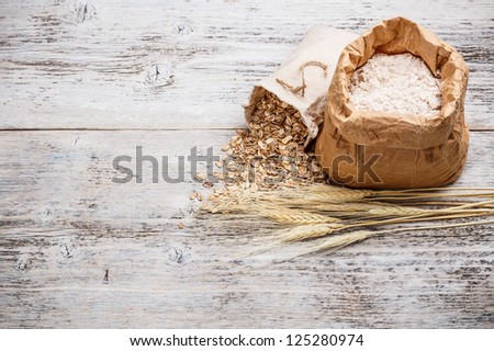 Whole flour in paper bag and oat flakes in canvas bag