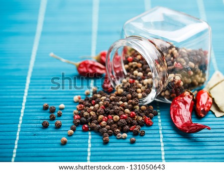 Mixture of different peppers sprinkled from a glass jar