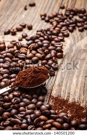 Coffee beans and ground coffee on old wooden table