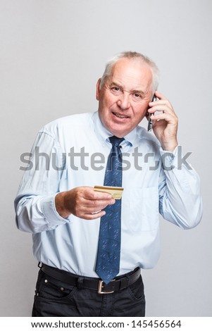 Standing middle aged businessman talking on cell phone