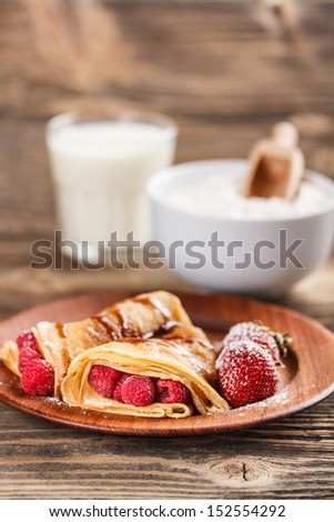Crepes with berries and chocolate topping