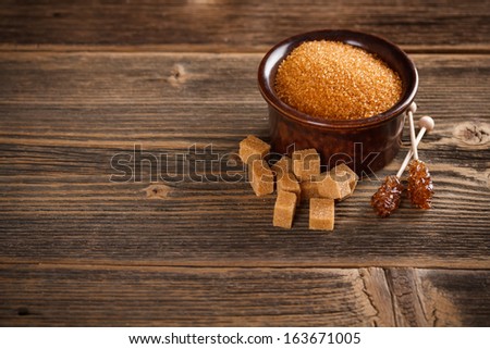 Brown sugar on old wooden background, space for text