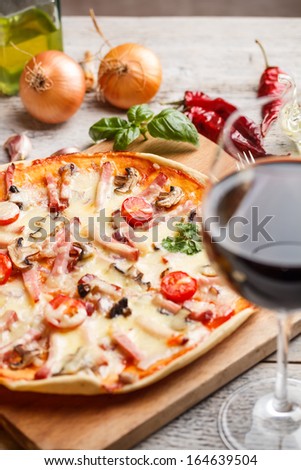 Delicious italian pizza served with red wine