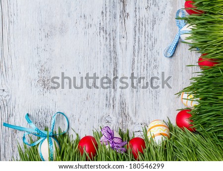Easter eggs and wooden eggs with ribbon hidden in the grass