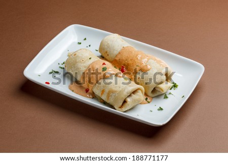 Rolled pancakes with minced meat and piquant sauce.