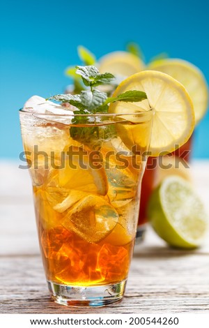 Glasses of iced tea with lemon, mint and ice cubes