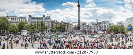 Trafalgar Square in London with blue sky and tourists passing by on August 13, 2014