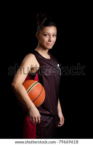 Smiling female basketball player, in black background