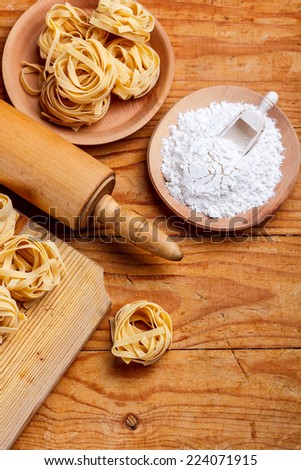 Tagliatelle and rolling-pin on wooden board