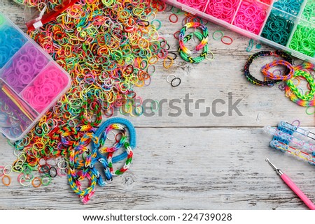 Colorful of elastic rainbow loom bands kit on wooden background