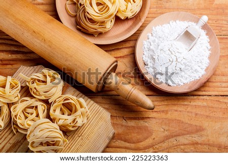 Rolling pin on cutting board with pasta and flour