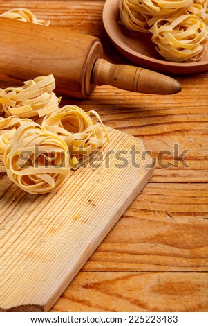 Tagliatelle and rolling-pin on wooden board