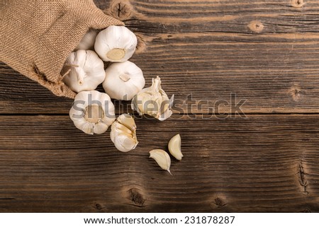 Garlic in a bag on rustic wooden board
