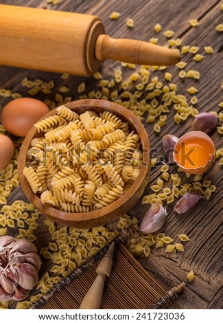 Whole wheat pasta in bowl on wooden board