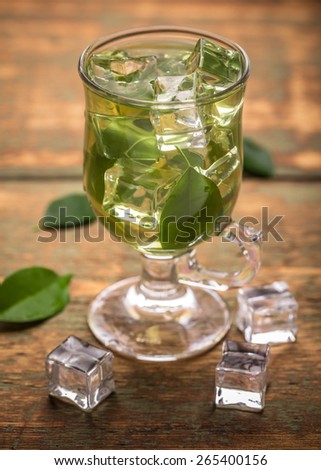 Cup of ice tea with green tea leaf