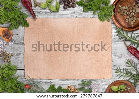 Green herbs as frame around a grungy paper for recipes