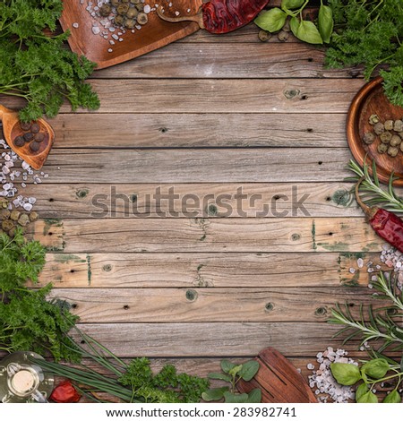 Freshly harvested herbs frame on vintage wooden background