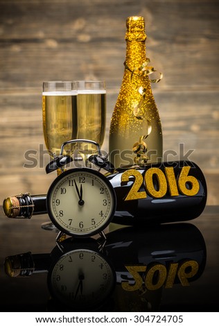 2016 New Year concept with the date in numbers, clock and bottle of champagne