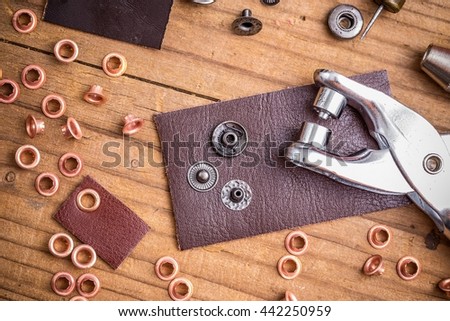 Tailor workplace with pieces of leather and rivets