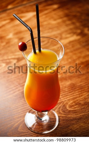 Cocktail with orange Juice on bar table, cherry decoration