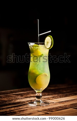 Green alcoholic cocktail with lime on white background