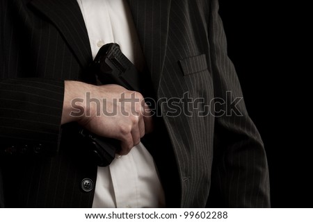 Man drawing his gun from coat pocket