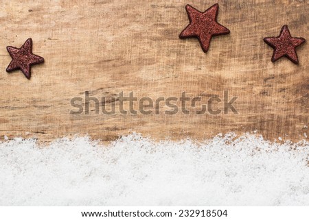 Snow and brown stars on wooden background - christmas decoration